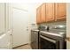 A laundry room with high-end washer and dryer units and wooden cabinets at 4415 E Weaver Rd, Phoenix, AZ 85050