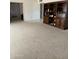 Spacious living room with wood shelving and carpeted floors at 5616 E Argyle Dr, Phoenix, AZ 85018