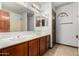 Bathroom with a double sink vanity, large mirror, and wood-paneled cabinets and doors at 6604 W Evans Dr, Glendale, AZ 85306