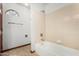 Bathroom featuring a bathtub with tiled walls and an arched window, offering natural light at 6604 W Evans Dr, Glendale, AZ 85306