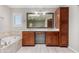 Bathroom with double vanity, large mirror, and separate tub at 6604 W Evans Dr, Glendale, AZ 85306
