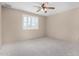 Neutral bedroom featuring plush carpeting, a ceiling fan, and bright, shuttered windows at 6604 W Evans Dr, Glendale, AZ 85306