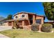 Exterior view of brick home featuring a well-kept lawn and mature landscaping at 6604 W Evans Dr, Glendale, AZ 85306