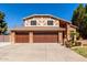 Two-story brick home with a three-car garage and well-maintained landscaping at 6604 W Evans Dr, Glendale, AZ 85306