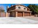 Side view of a two-story home with a three-car garage and brick exterior at 6604 W Evans Dr, Glendale, AZ 85306