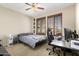 Bedroom featuring a ceiling fan, two windows with wooden shutters, and desk area at 6605 N 93Rd Ave # 1101, Glendale, AZ 85305