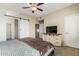 Cozy bedroom with barn door, ceiling fan, and TV on the wall at 6605 N 93Rd Ave # 1101, Glendale, AZ 85305