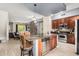 Open concept kitchen features stainless steel appliances and granite counters with seating and stone fireplace in the living room at 6605 N 93Rd Ave # 1101, Glendale, AZ 85305