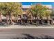 Exterior street view of townhomes with a modern design, trees, and well-maintained landscaping at 6605 N 93Rd Ave # 1101, Glendale, AZ 85305