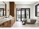 Bright bathroom featuring a stand-alone tub, double vanity, and access to a private patio at 6825 N 39Th Pl, Paradise Valley, AZ 85253