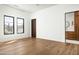 Bright, empty room with hardwood floors, dark trim windows, and a connecting bathroom at 6825 N 39Th Pl, Paradise Valley, AZ 85253