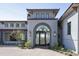 Elegant home entrance with arched doorway, accent lighting, and lush landscaping at 6825 N 39Th Pl, Paradise Valley, AZ 85253