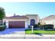 Charming home featuring a two-car garage, red tile roof, arched window, and well-maintained front yard at 8055 E Cortez Dr, Scottsdale, AZ 85260