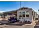Mobile home with covered patio and golf cart at 8700 E University Dr # 737, Mesa, AZ 85207