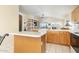 Kitchen with an island and wood cabinets, open to living area at 8957 E Rainier Dr, Gold Canyon, AZ 85118