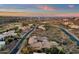 Panoramic aerial view of desert homes, showcasing a golf course and distant mountains during a colorful sunset at 9815 N Copper Ridge Trl, Fountain Hills, AZ 85268