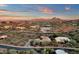 Scenic aerial view of a desert home with a terracotta roof, set against a backdrop of mountains and a colorful sunset at 9815 N Copper Ridge Trl, Fountain Hills, AZ 85268