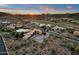 Expansive aerial view of desert homes with golf course and stunning mountain views under a vibrant sunset sky at 9815 N Copper Ridge Trl, Fountain Hills, AZ 85268