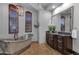 Elegant bathroom with a freestanding tub, wooden shutters, dark vanity, and beautiful finishes at 9815 N Copper Ridge Trl, Fountain Hills, AZ 85268
