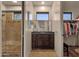 Bathroom showcasing a dark vanity with a mirror, shower with glass door, and storage area at 9815 N Copper Ridge Trl, Fountain Hills, AZ 85268