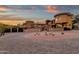 Stunning home exterior with circular driveway, desert landscaping, and stone accents beneath a vibrant sunset sky at 9815 N Copper Ridge Trl, Fountain Hills, AZ 85268