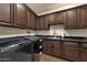 Well-equipped laundry room with dark wood cabinetry, granite countertops, and modern washer/dryer at 9815 N Copper Ridge Trl, Fountain Hills, AZ 85268