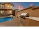 Backyard kitchen with a built-in grill, counter space, and seating area near the pool at 9815 N Copper Ridge Trl, Fountain Hills, AZ 85268