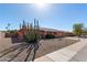 Single story home with peach stucco exterior, two-car garage, and a large cacti at 11029 W Meade Dr, Sun City, AZ 85351