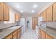 Galley kitchen with wood cabinets and modern appliances at 11029 W Meade Dr, Sun City, AZ 85351