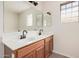 Bathroom with double vanity, large mirror, and window at 11465 W Virginia Ave, Avondale, AZ 85392