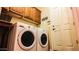 Bright laundry room with washer, dryer, and ample cabinets at 14335 W Monte Vista Rd, Goodyear, AZ 85395