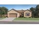 Single-story home with tan exterior, brown roof, and a 3-car garage at 15056 W Gray Fox Trl, Surprise, AZ 85387