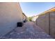 Small, walled backyard with stone pavers and minimal desert landscaping at 15804 N 109Th Dr, Sun City, AZ 85351