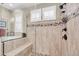 Luxurious shower with a tile surround, built-in bench, glass enclosure, and river rock floor at 15804 N 109Th Dr, Sun City, AZ 85351