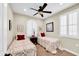 Neutral bedroom with two twin beds, ceiling fan, and plantation shutters at 15804 N 109Th Dr, Sun City, AZ 85351