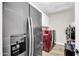 Laundry area with modern washer and dryer, storage shelves, and adjacent stainless refrigerator at 15804 N 109Th Dr, Sun City, AZ 85351