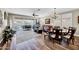 Open-concept living room with hardwood floors, a ceiling fan, and an elegant chandelier at 15804 N 109Th Dr, Sun City, AZ 85351