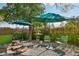 Back yard featuring two umbrellas, a fire pit, and a patio seating area at 1638 E Earll Dr, Phoenix, AZ 85016