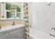 Bathroom with a shower-tub combo, white tiling, and a window for natural light at 1638 E Earll Dr, Phoenix, AZ 85016