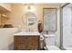 Well-lit bathroom featuring a wooden vanity, round mirror, and stylish decor at 1638 E Earll Dr, Phoenix, AZ 85016