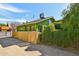 View of a green single story home with a bamboo fence and large green hedge at 1638 E Earll Dr, Phoenix, AZ 85016