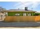 View of a green one-story home with a bamboo fence and sunny sky at 1638 E Earll Dr, Phoenix, AZ 85016