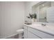 Small bathroom with a modern white vanity and patterned wallpaper at 16770 W Alameda Rd, Surprise, AZ 85387