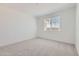 Neutral bedroom with plush carpeting, a window providing natural light, and blank walls at 17399 W Whispering Wind Dr, Surprise, AZ 85387