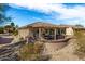 Landscaped backyard with covered patio and gravel at 18727 N Desert Light Dr, Surprise, AZ 85387