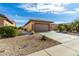 View of the garage and side yard of a tan house at 18727 N Desert Light Dr, Surprise, AZ 85387