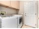 Laundry room with washer, dryer, cabinets, and additional storage at 18727 N Desert Light Dr, Surprise, AZ 85387