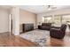 Living room with hardwood floors, leather furniture and large windows at 18727 N Desert Light Dr, Surprise, AZ 85387