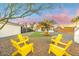 Charming backyard with artificial turf, picnic table, and yellow chairs at 1921 W Monte Vista Rd, Phoenix, AZ 85009