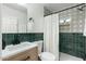 Updated bathroom with a green tile shower and modern vanity at 1921 W Monte Vista Rd, Phoenix, AZ 85009